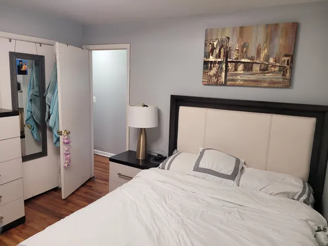 a bedroom with a bed and a painting on the wall