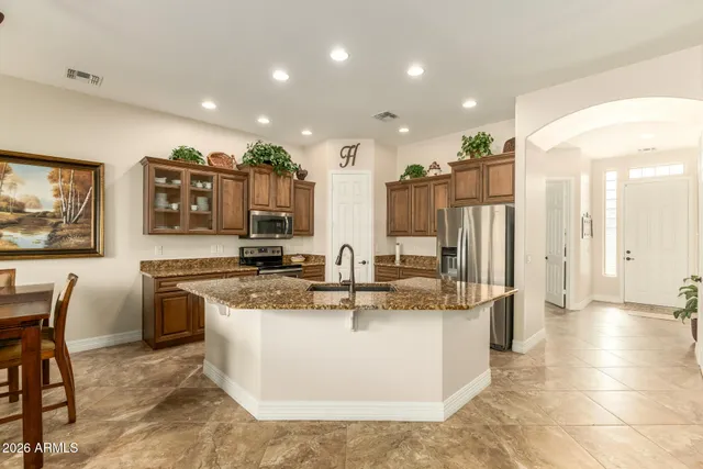 a view of a kitchen with stainless steel appliances granite countertop a sink and a refrigerator