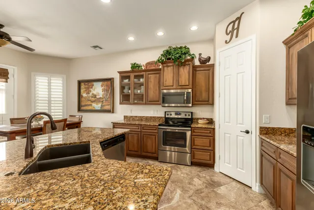 a kitchen with granite countertop a sink stove and refrigerator