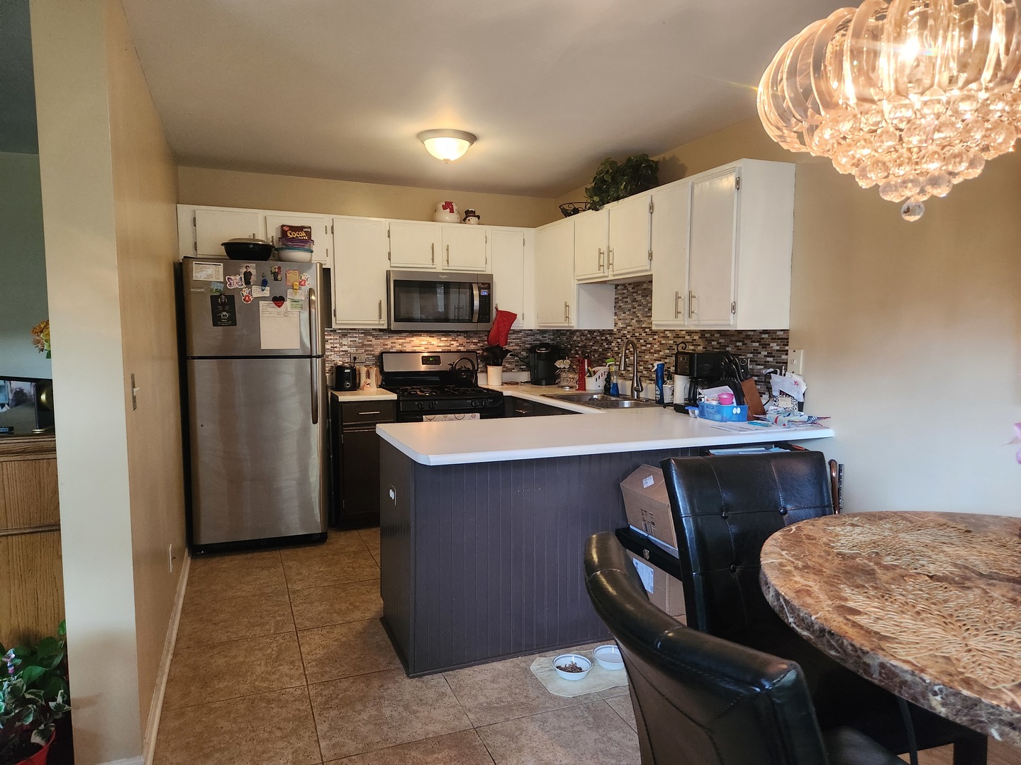 1013 Saxon Court, Unit B Elgin, IL 60120 - Photo 6 of 17 a kitchen with stainless steel appliances granite countertop a refrigerator a sink a stove a microwave a refrigerator and cabinets