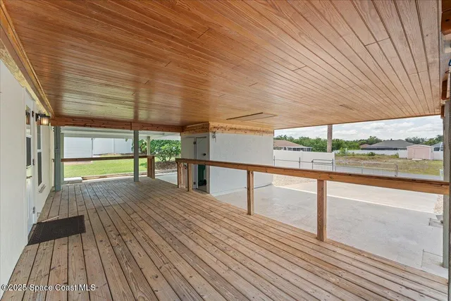a view of a big room with windows and chandelier