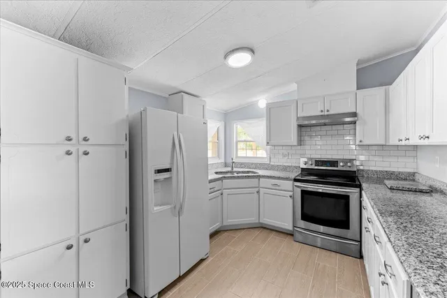 a kitchen with granite countertop a sink and a window