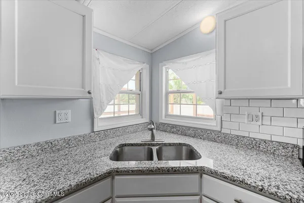 a kitchen with granite countertop white cabinets and white appliances