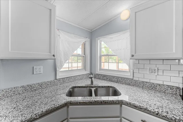 a kitchen with granite countertop white cabinets and white appliances