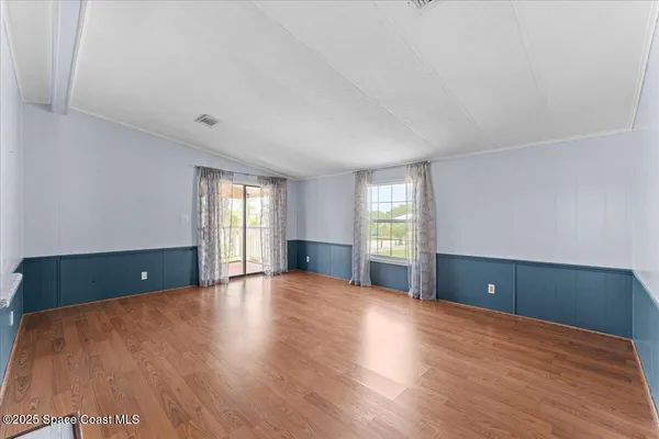 a view of a room with wooden floor and large windows