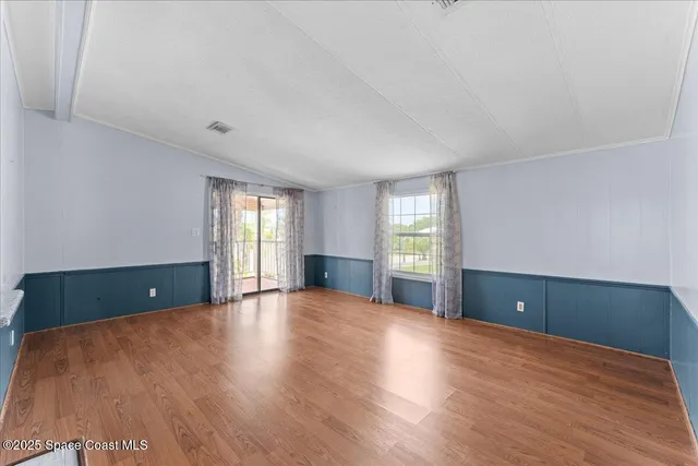 a view of a room with wooden floor and large windows