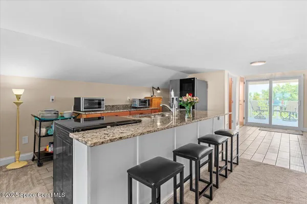a kitchen with stainless steel appliances kitchen island granite countertop a refrigerator and a stove top oven