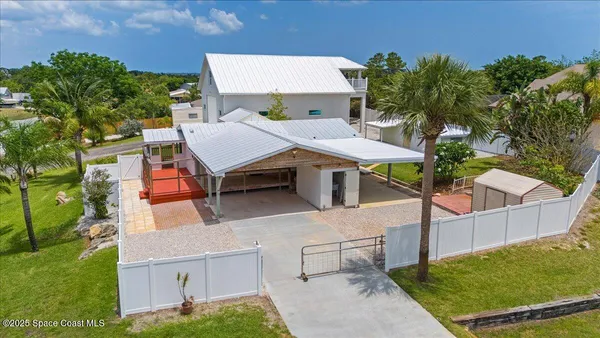 an aerial view of a house with swimming pool and sitting area