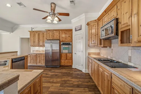 a kitchen with stainless steel appliances granite countertop a refrigerator a stove and a sink with cabinets