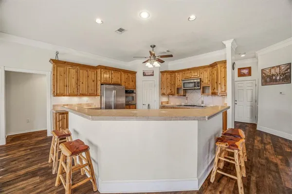 a kitchen with stainless steel appliances granite countertop a sink and a refrigerator