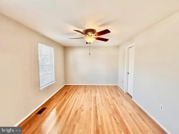 a view of a room with wooden floor and a ceiling fan