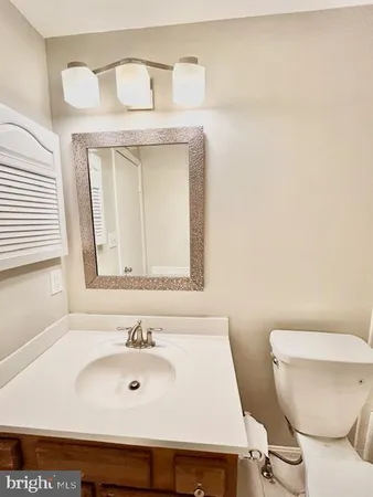a bathroom with a toilet a sink and a mirror