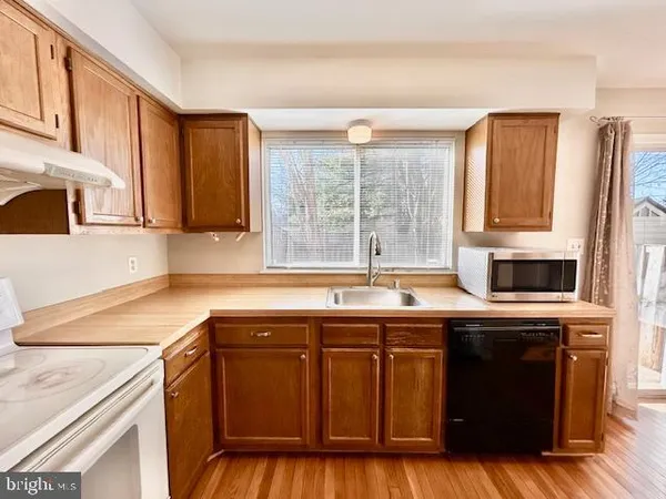 a kitchen with stainless steel appliances granite countertop a sink a stove and a refrigerator
