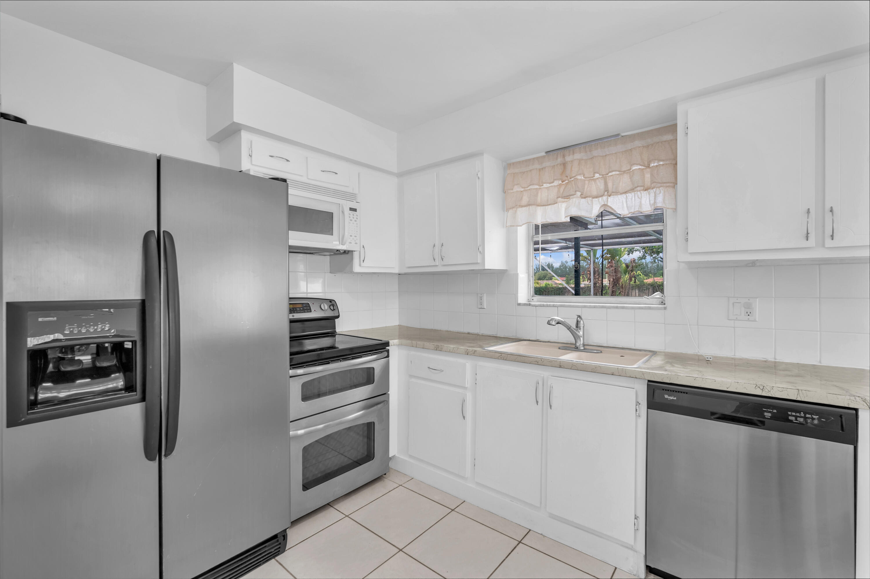 10985 Christopher Avenue Boca Raton, FL 33428 - Photo 5 of 24 a kitchen with stainless steel appliances a refrigerator sink and microwave