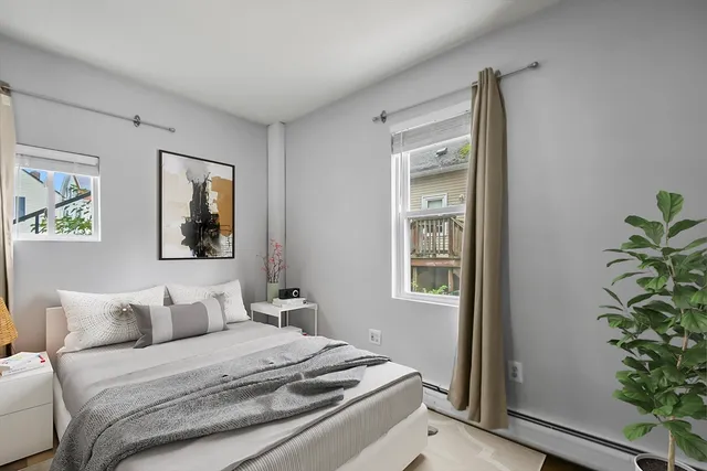 a bedroom with a bed and a potted plant