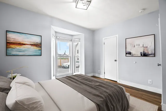 a bedroom with a bed and a painting on the wall