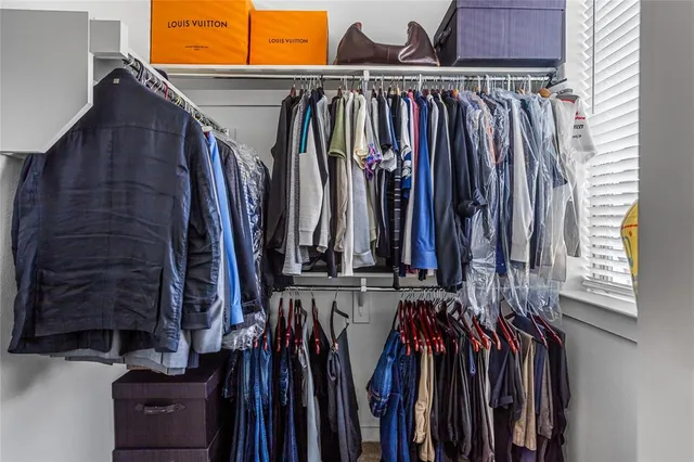 a view of walk in closet with clothes
