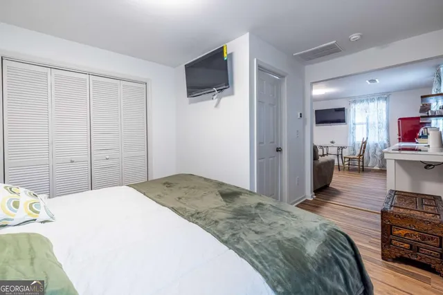 a spacious bedroom with a bed and a flat screen tv