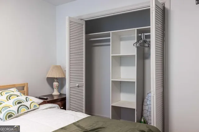 a bedroom with a bed and a lamp on the dresser