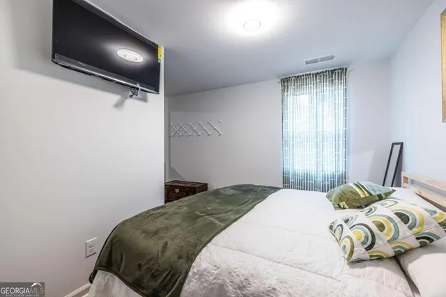 a bedroom with a bed and flat screen tv