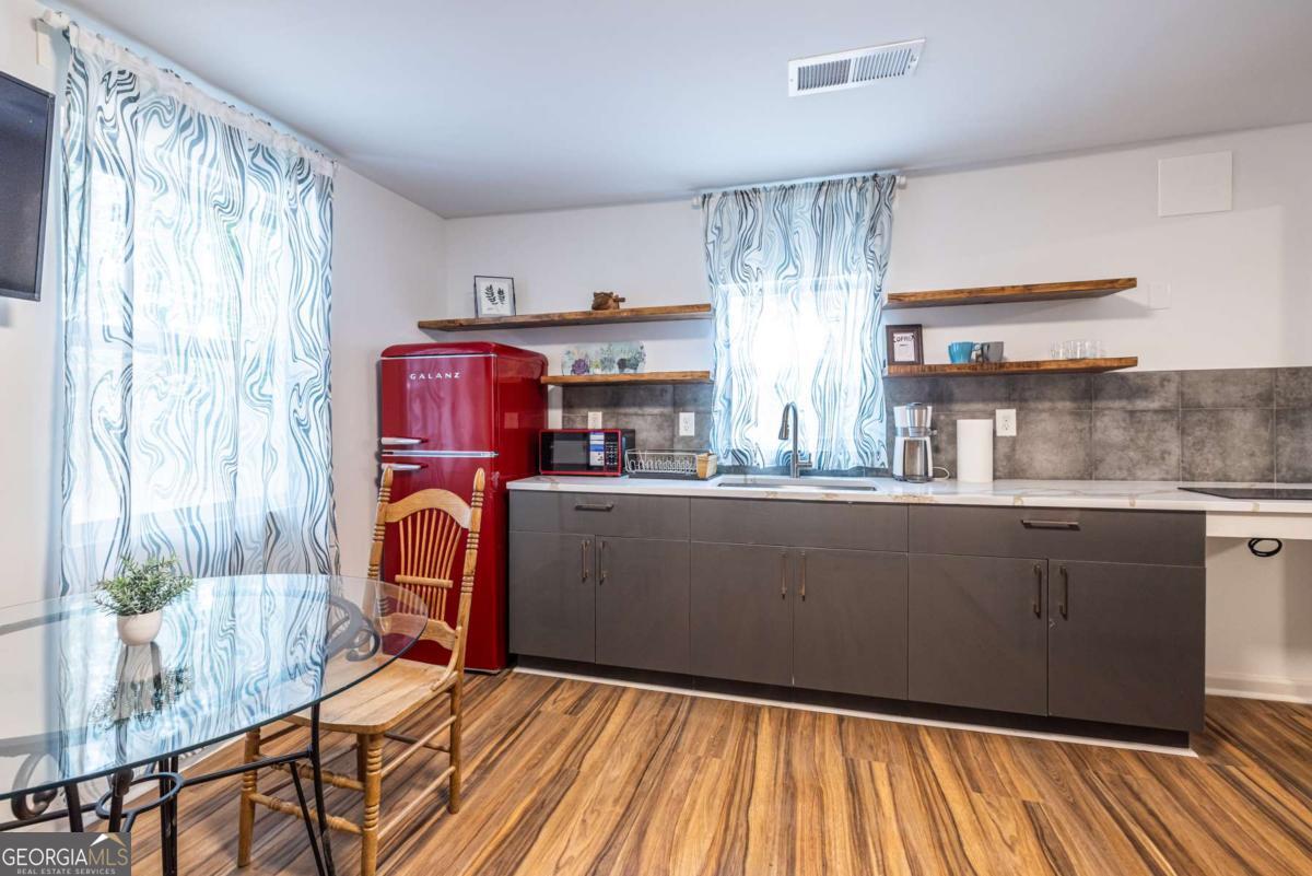 4350 Welcome All Road, Unit 1 Atlanta, GA 30349 - Photo 7 of 22 a kitchen with stainless steel appliances granite countertop a refrigerator a sink dishwasher and wooden cabinets with wooden floor