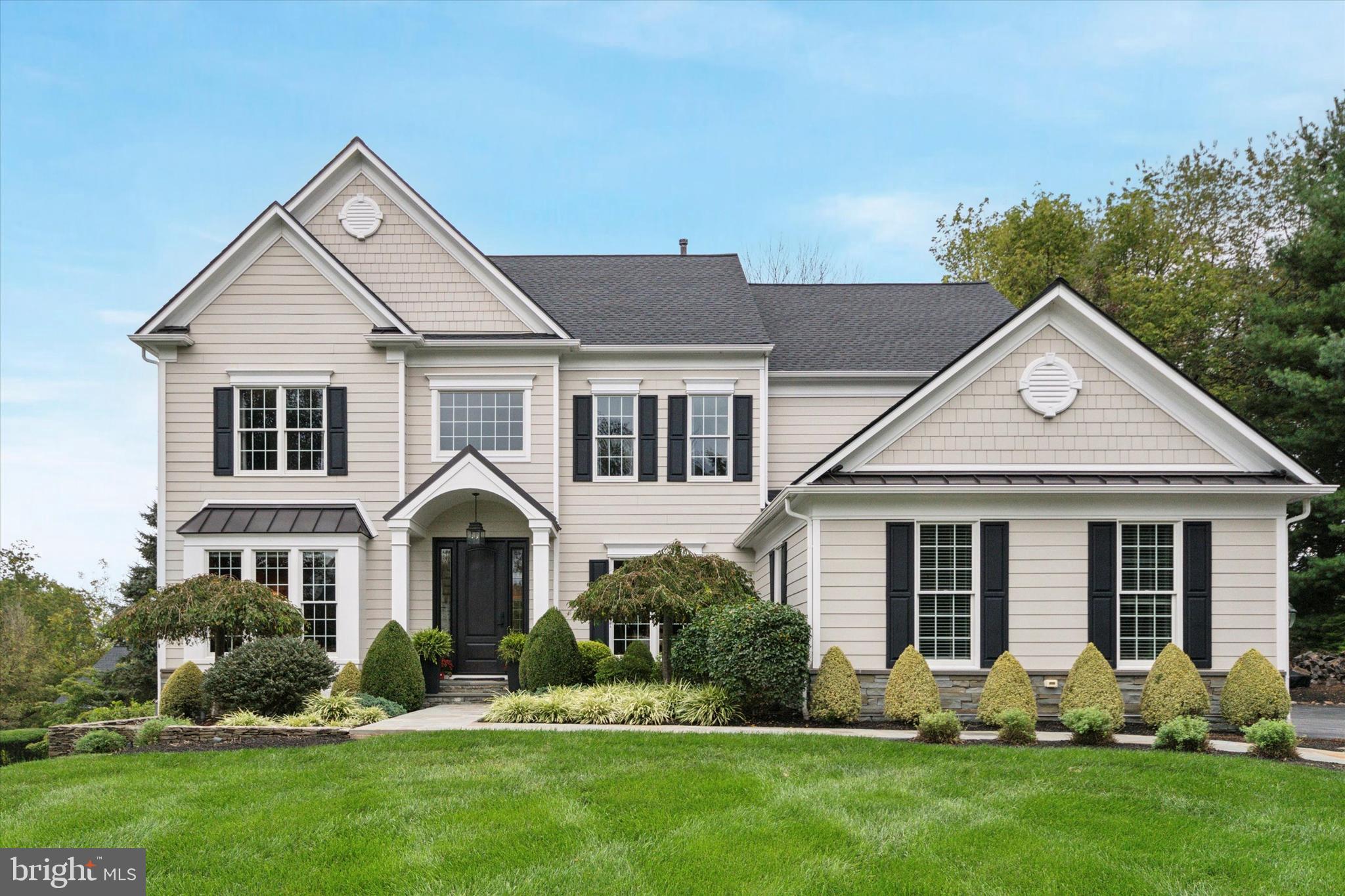 a front view of a house with a yard and green space
