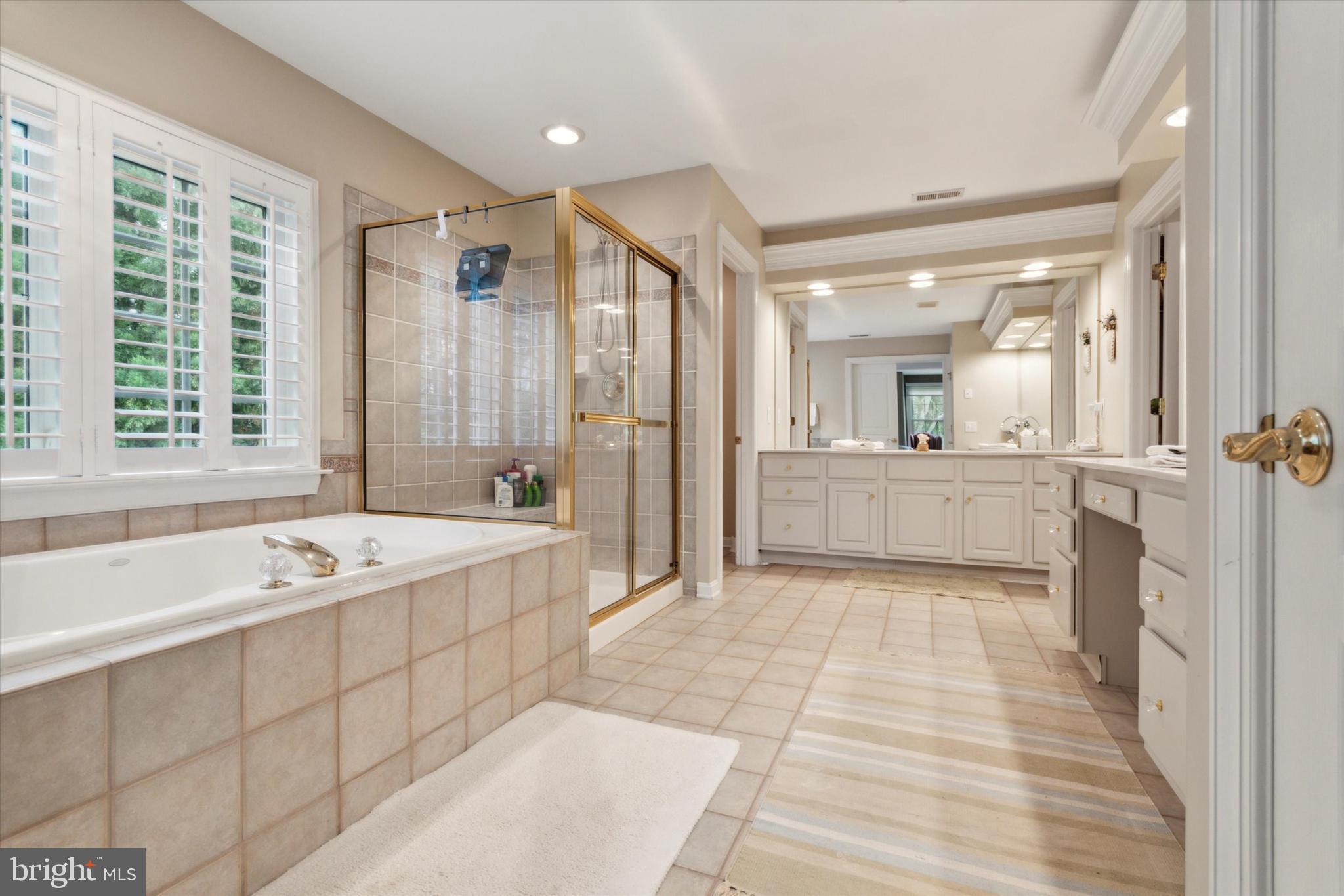 1007 Ridgehaven Road West Chester, PA 19382 - Photo 21 of 36 a spacious bathroom with a tub sink shower and mirror