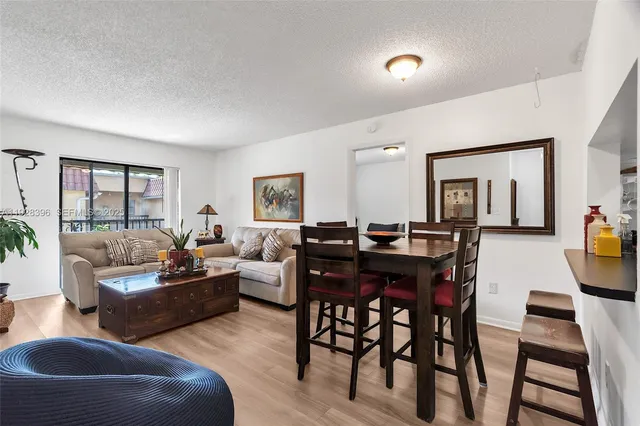 a living room with furniture a desk and a large window