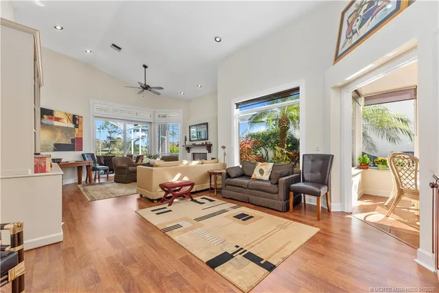 a living room with furniture large window and wooden floor