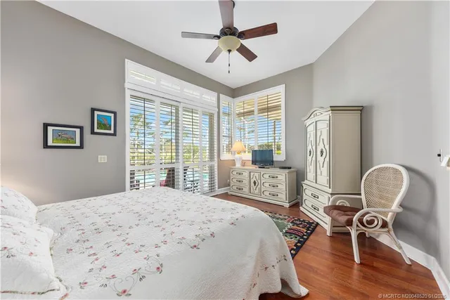 a bedroom with a bed dresser and a large window