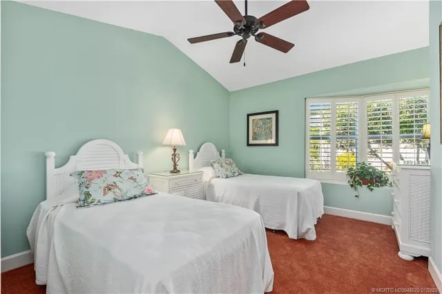 a bedroom with two beds and a potted plant