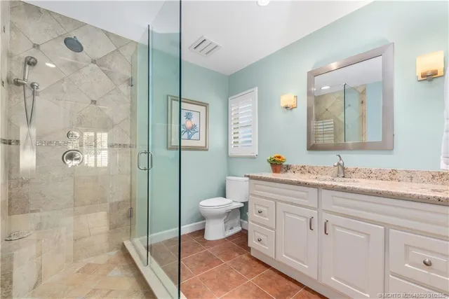 a bathroom with a double vanity sink toilet and shower
