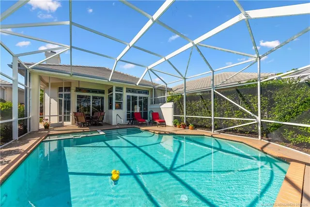 a view of a swimming pool with a patio and a yard