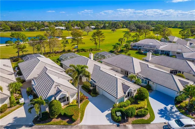an aerial view of residential houses with outdoor space and lake view