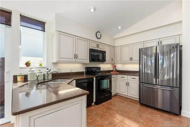 a kitchen with kitchen island a sink appliances and cabinets