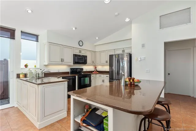 a kitchen with stainless steel appliances granite countertop a kitchen island a stove a table and chairs