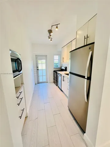 a view of kitchen with refrigerator microwave and wooden floor