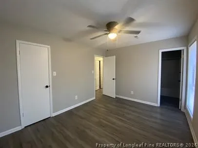 an empty room with wooden floor and ceiling fan