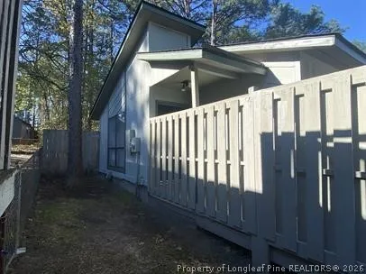 a view of a house with a yard and wooden fence