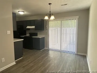 a view of a kitchen with wooden floor and a refrigerator