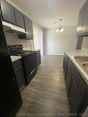 a kitchen with granite countertop a stove and a sink
