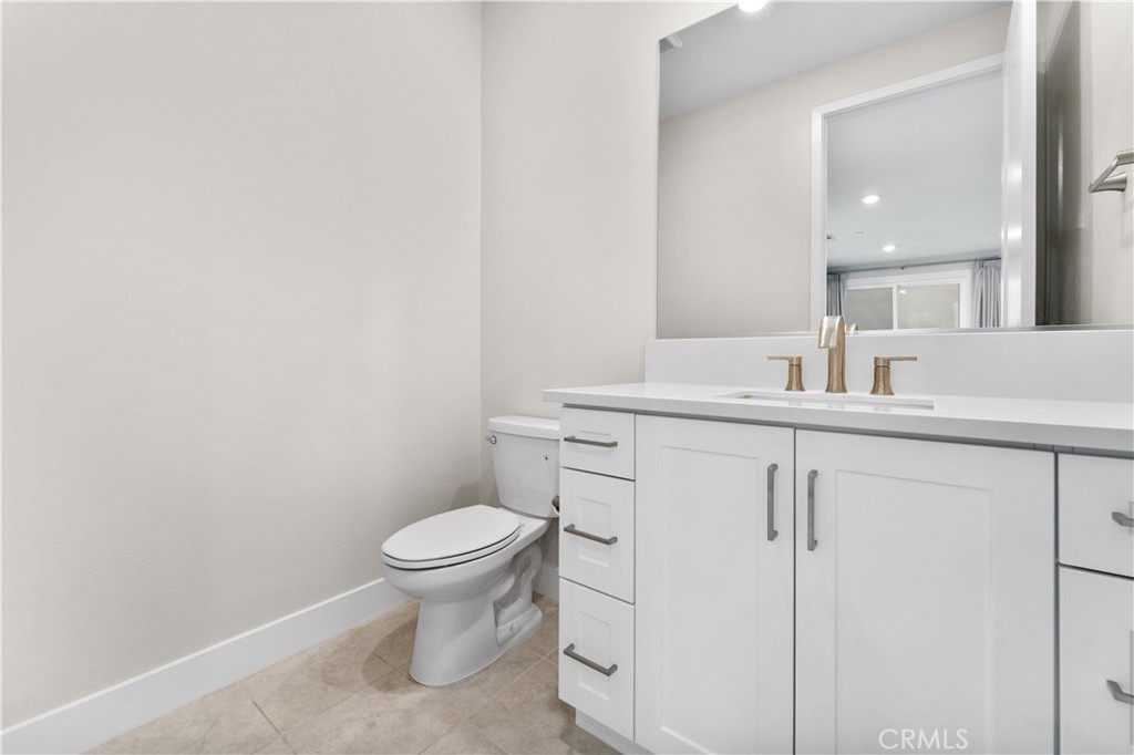 115 Rondo Irvine, CA 92618 - Photo 4 of 28 a bathroom with a granite countertop sink a toilet and a mirror