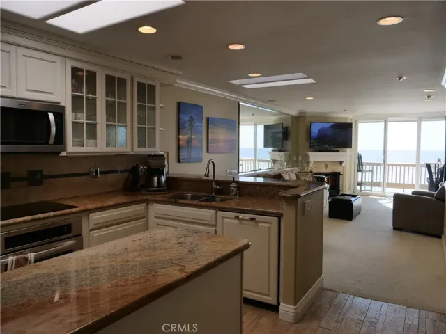 a kitchen with granite countertop a sink stove and cabinets