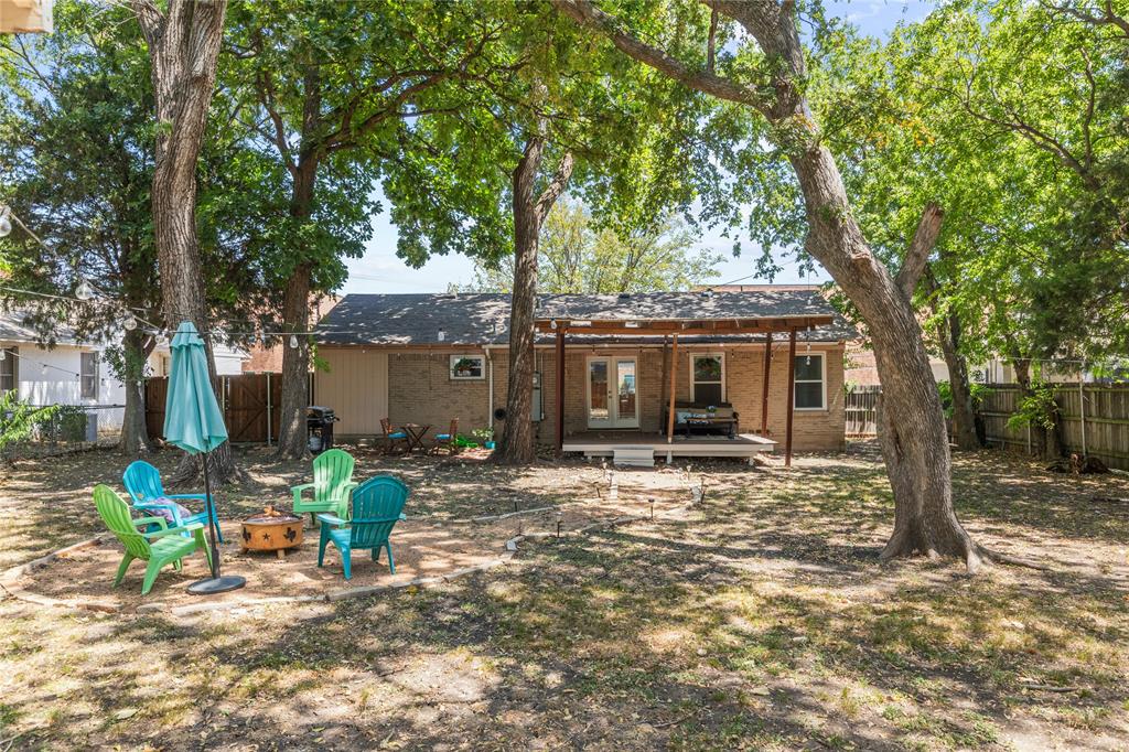 649 Peavy Road Dallas, TX 75218 - Photo 21 of 30 Expansive backyard featuring mature trees, a wooden deck, and a covered patio structure