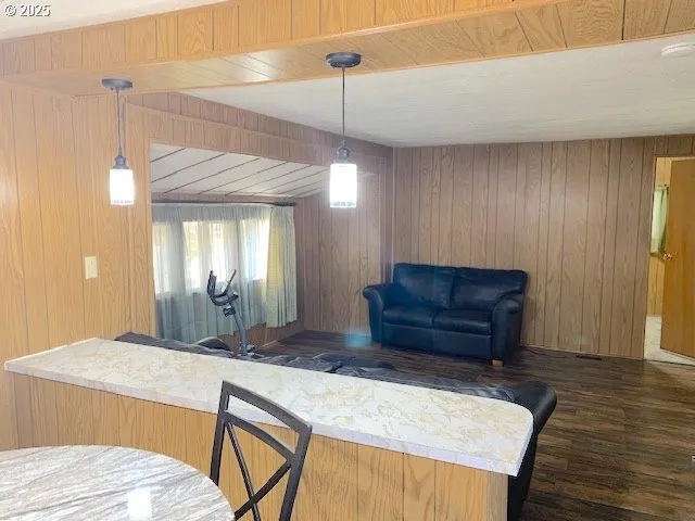 a room with a bed a dresser and wooden floor