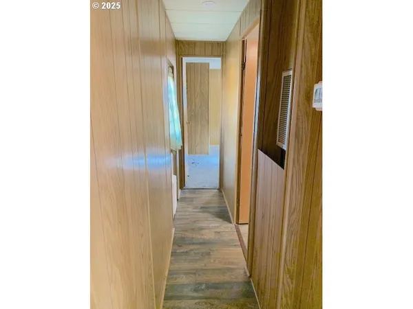 a view of a hallway with wooden floor