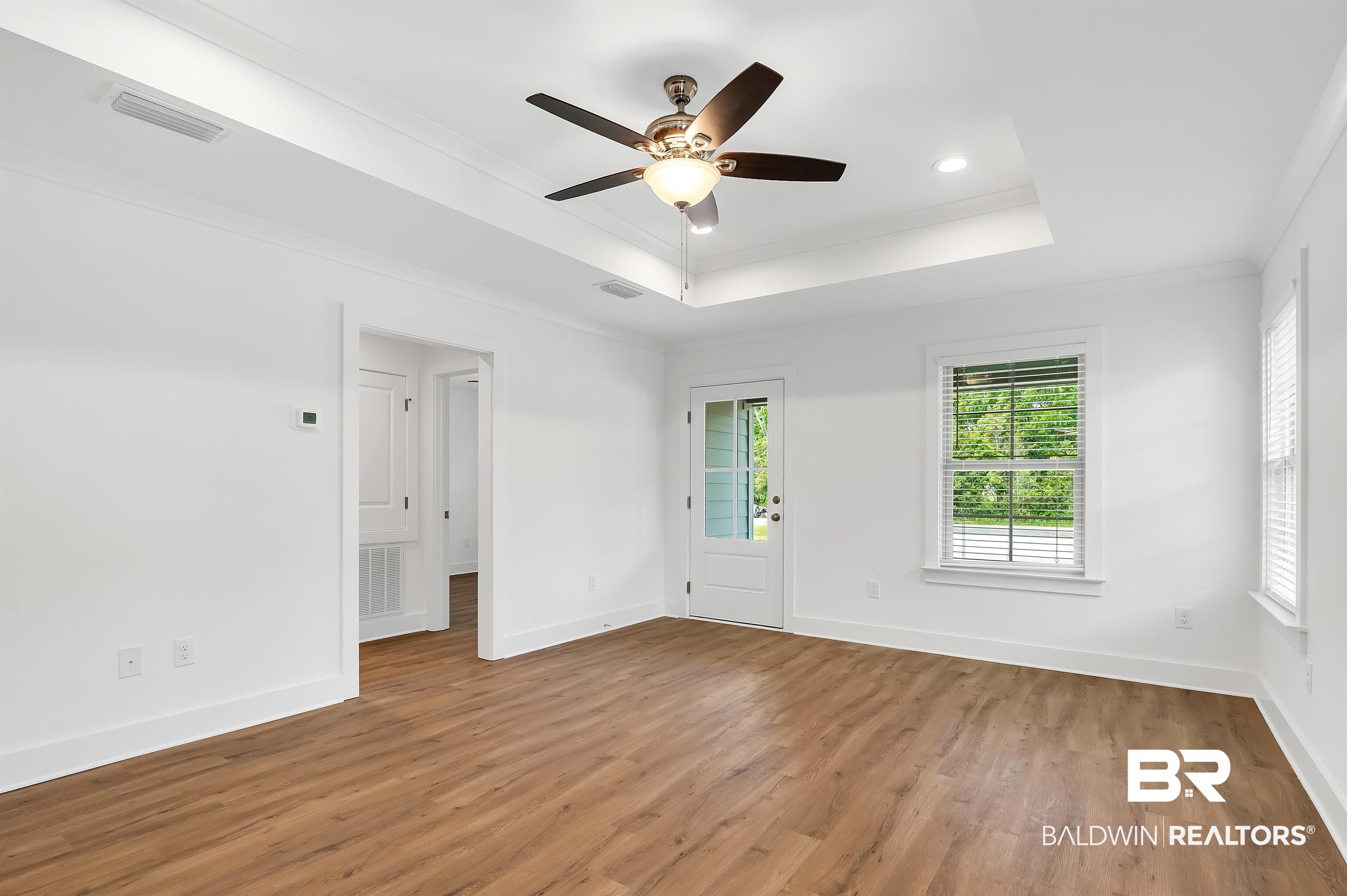 22045 8th Street Silverhill, AL 36576 - Photo 7 of 39 Living area with a tray ceiling, ornamental molding, light wood finished floors, baseboards, and recessed lighting