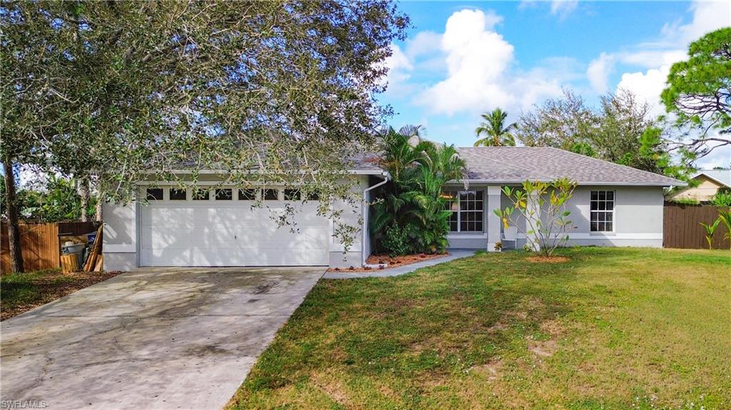 18282 Fern Road Fort Myers, FL 33967 - Photo 2 of 24 a front view of a house with a garden and trees