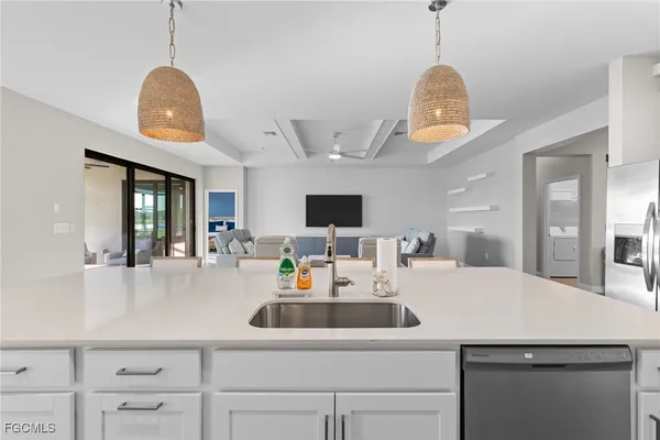 a kitchen with a sink dishwasher a dining table and chairs with wooden floor