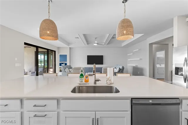 a kitchen with a sink dishwasher a dining table and chairs with wooden floor